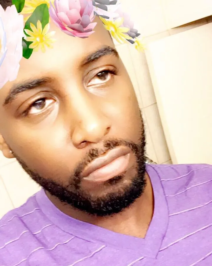 Homme torse nu, sous-vêtements noirs, dans une douche, regard vers le côté.