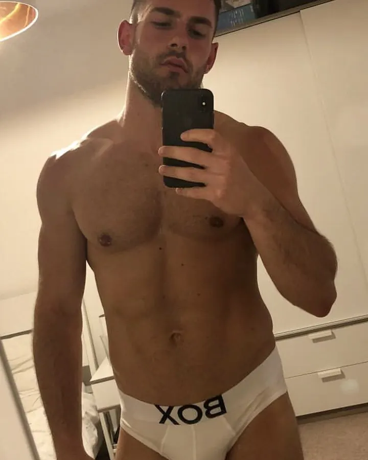 Jeune homme torse nu, regard direct, photo en gros plan, en extérieur.